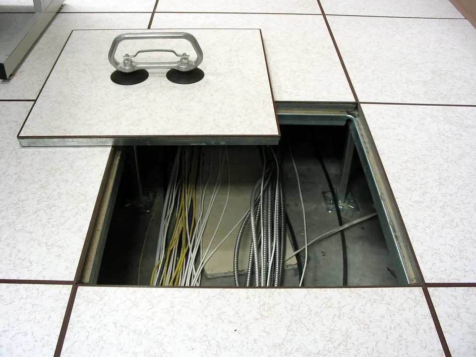 Raised-floor tile removed to show cable cut-out and cabling below